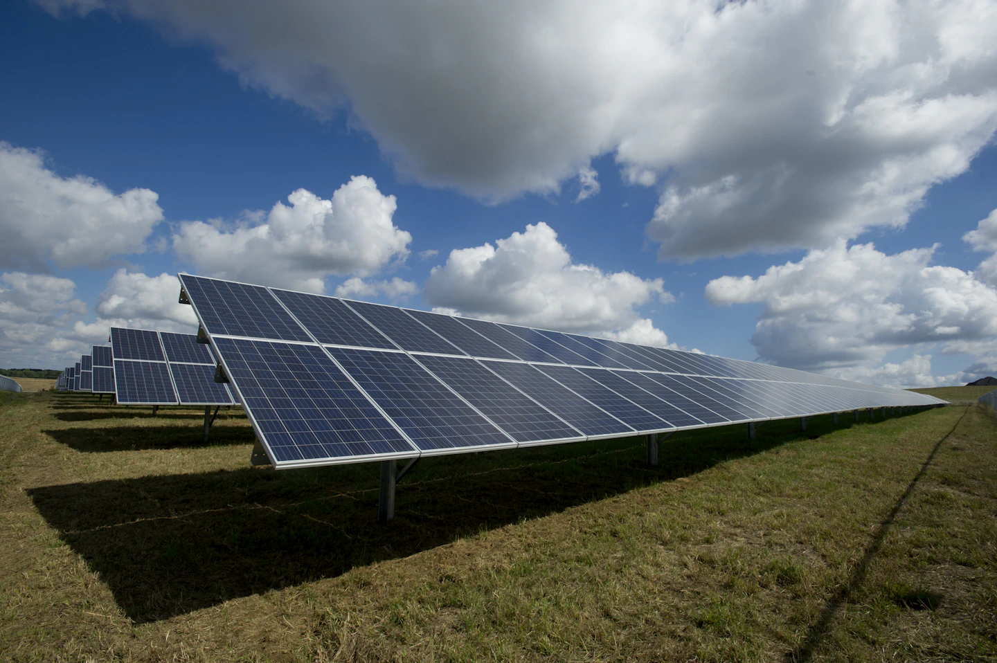 Rows of solar panels at an outdoor power generation facility.