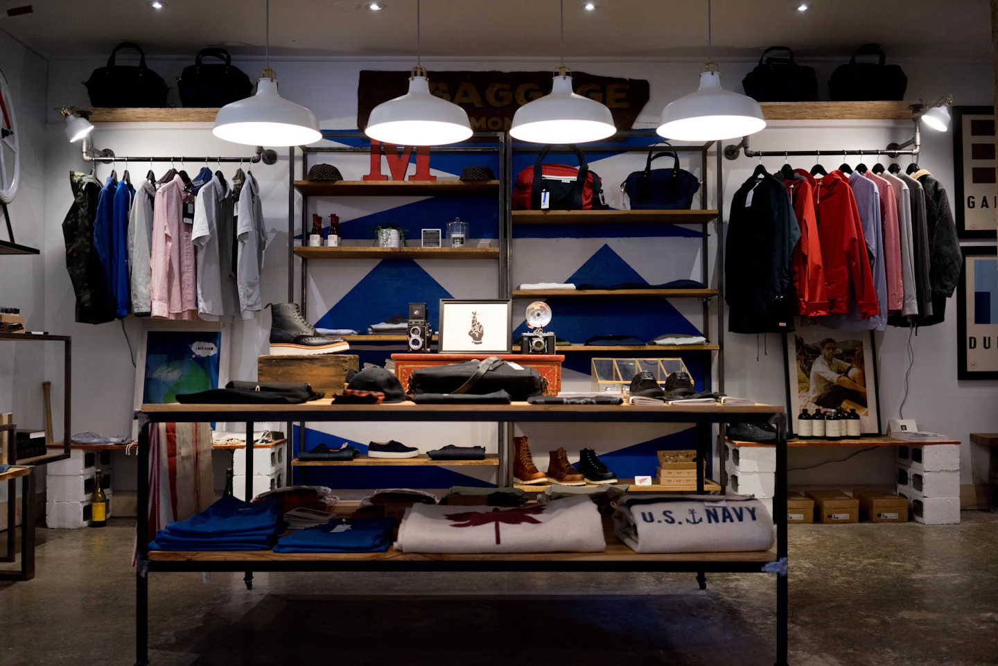 Clothing and accessories arranged on racks and display tables in a retail store.